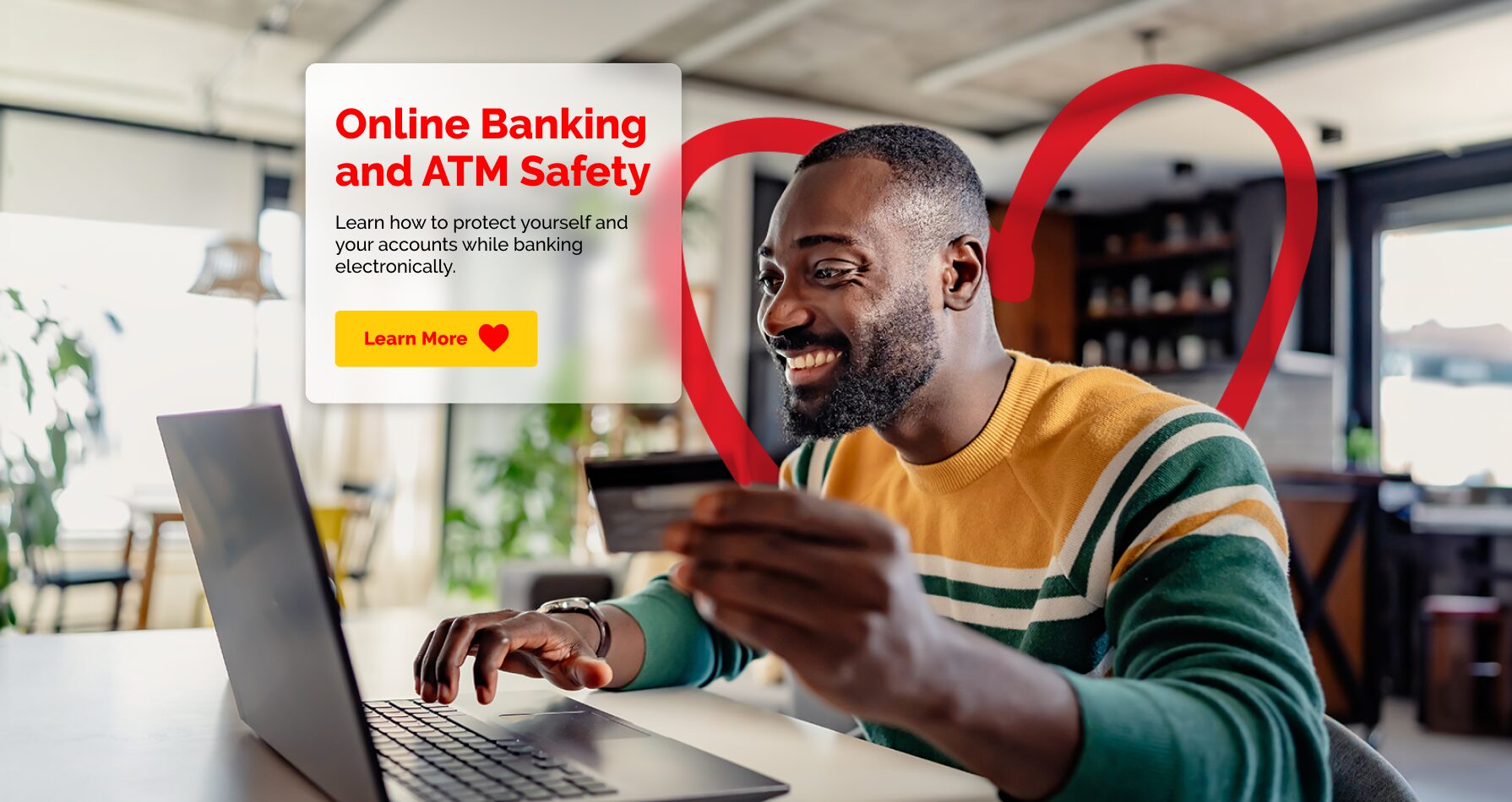 JMMB Jamaica website header showing a man using a laptop and holding a bank card with messaging about online banking and ATM safety, featuring an illustrated heart in the background.